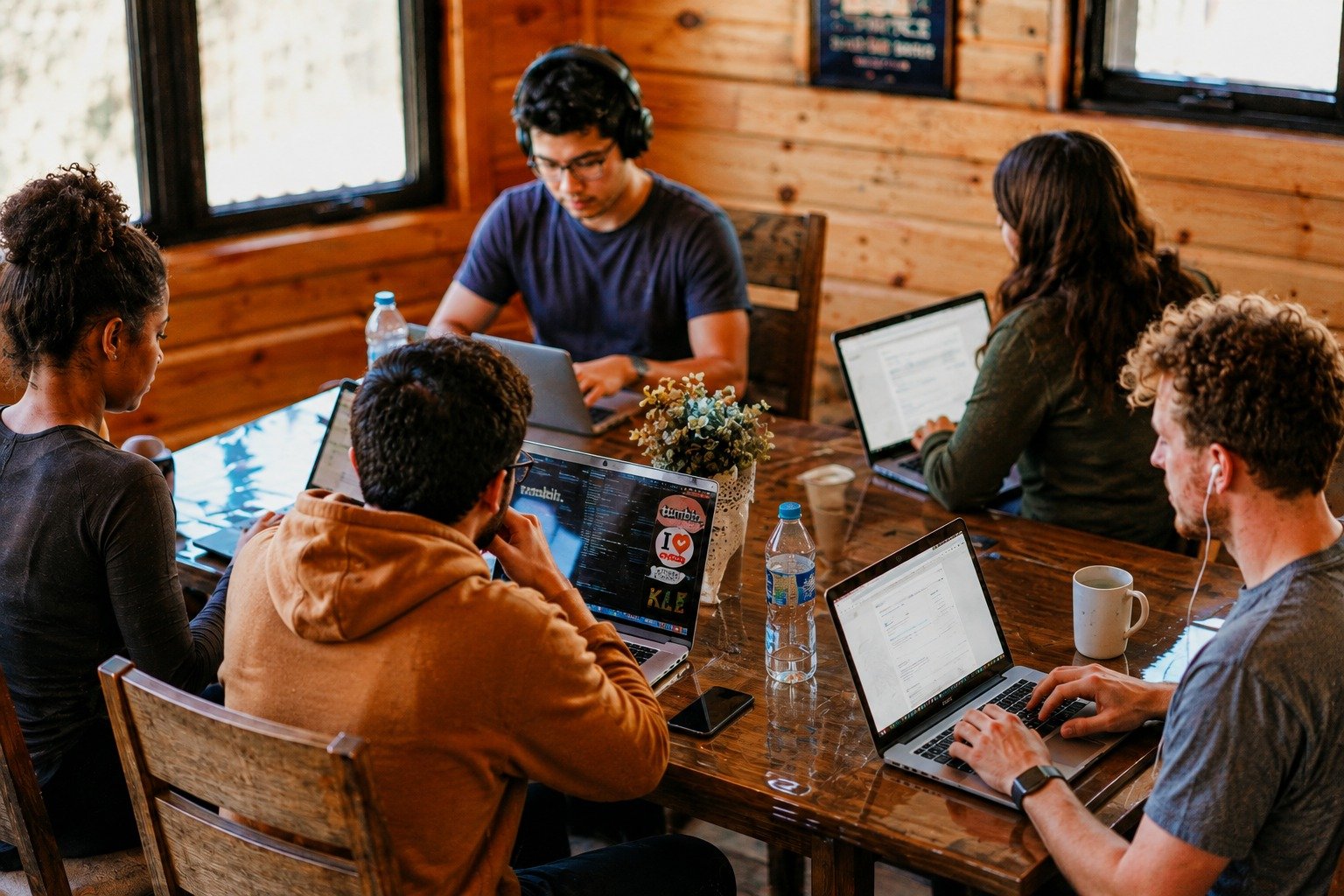 Digital marketing team collaborating on laptops in a creative workspace